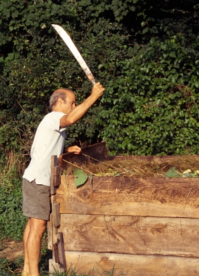 Chopping compost with machete